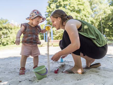 Little girl with her mother in sandbox on playground - LAF02351