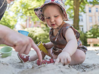Portrait of little girl with her mother in sandbox on playground - LAF02353