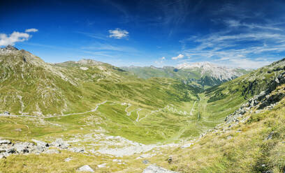 Panorama der kurvenreichen Straße und des grünen Tals in Richtung des Dorfs Splugen, Splugapass, Kanton Graubünden, Schweiz, Europa - RHPLF03503