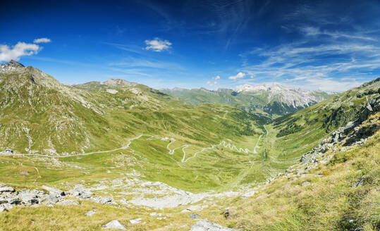 Panorama der kurvenreichen Straße und des grünen Tals in Richtung des Dorfs Splugen, Splugapass, Kanton Graubünden, Schweiz, Europa - RHPLF03503