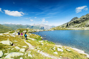 Wanderer auf Wanderweg am Ufer des Bergsees, Splugapass, Kanton Graubünden, Schweiz, Europa - RHPLF03506