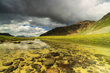 Gewitterwolken auf dem Piz Umbrail, die sich im unberührten Bergsee spiegeln, Stilfserjoch, Braulio-Tal, Valtellina, Lombardei, Italien, Europa - RHPLF03529