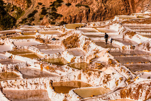 Salzterrassen im Heiligen Tal, wo die Menschen noch immer die terrassenförmig angelegten Becken abbauen und sichten, wie es die Inkas vor 1000 Jahren taten, Peru, Südamerika - RHPLF03537