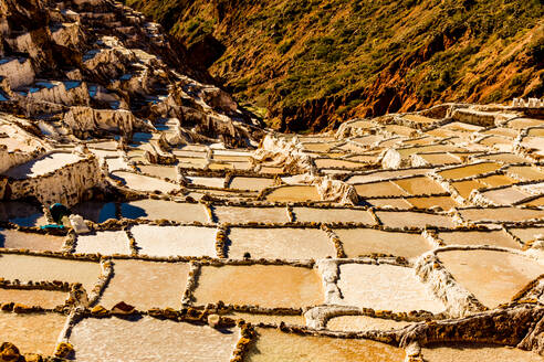 Salzterrassen im Heiligen Tal, wo die Menschen noch immer die terrassenförmig angelegten Becken abbauen und sichten, wie es die Inkas vor 1000 Jahren taten, Peru, Südamerika - RHPLF03539