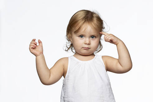 Portrait of blond girl tapping one's forehead, white background - VGF00276