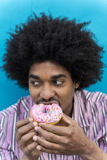 Young man eating donut - AFVF03809