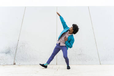 Junger Hipster-Mann tanzt, weiße Wand im Hintergrund - AFVF03830