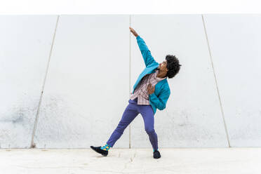 Young hipster man dancing, white wall in the background - AFVF03830