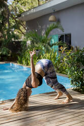 Frau übt Yoga am Pool, Costa Rica - MAUF02749