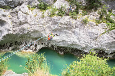 Mann überquert den Fluss Verdon an einem Seil, Provence-Alpes-Cote d'Azur, Provence, Frankreich, Europa - RHPLF03634