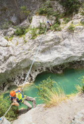 Mann überquert den Fluss Verdon an einem Seil, Provence-Alpes-Cote d'Azur, Provence, Frankreich, Europa - RHPLF03635