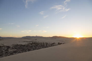 The sun setting over the dramatic Dunas de Corralejo on the volcanic island of Fuerteventura with mountains beyond, Fuerteventura, Canary Islands, Spain, Europe - RHPLF03930