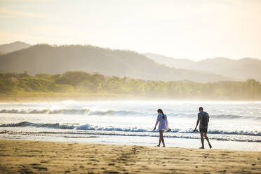 Pärchen am Strand Playa Buena Vista bei Sonnenaufgang, Provinz Guanacaste, Costa Rica, Mittelamerika - RHPLF04042
