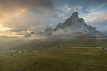 Blick auf Landschaft und kurvenreiche Straße vom Marmoladapass bei Sonnenuntergang, Südtirol, Italienische Dolomiten, Italien, Europa - RHPLF04106