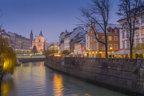 Verschnörkelte Fassade der Franziskanerkirche Mariä Verkündigung und der Fluss Ljubljanica in der Abenddämmerung, Ljubljana, Slowenien, Europa - RHPLF04299