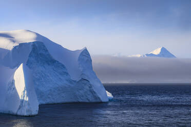 Riesiger Eisberg und Berg, sich lichtender Nebel, Bransfield Strait, in der Nähe der Süd-Shetland-Inseln und der Antarktischen Halbinsel, Antarktis, Polarregionen - RHPLF04302