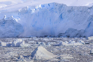 Eislawine, Gletscherkalbung in den mit Eisbergen gefüllten Neko Harbour, frühe Morgensonne, Graham Land, Antarktischer Kontinent, Antarktis, Polarregionen - RHPLF04416