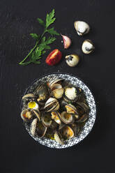 Directly above shot of clams in plate by ingredients on black background - MAUF02771