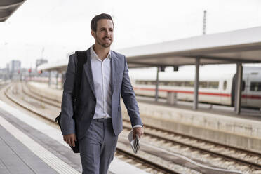 Businessman walking on station platform - DIGF08107