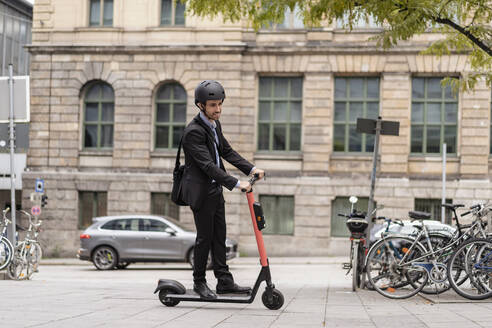 Geschäftsmann fährt E-Roller in der Stadt - DIGF08124