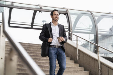 Geschäftsmann mit Kaffee zum Mitnehmen auf einer Treppe in der Stadt - DIGF08127