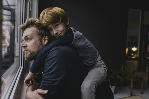 Father and son hanging out at home on rainy day - KNSF06300