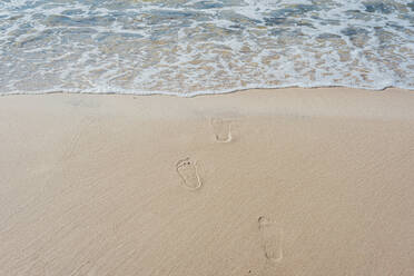 Hohe Winkel Ansicht der Fußabdrücke auf Meer Ufer am Strand in Polen - MJF02419