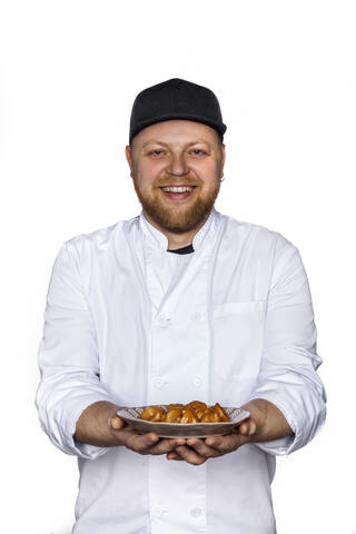 Porträt einer lächelnden Köchin, die einen Teller mit Pelmeni serviert, lizenzfreies Stockfoto