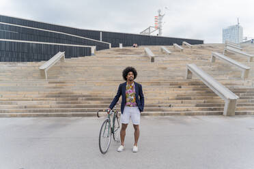 Stilvoller Mann mit Fahrrad an einer Treppe stehend - AFVF03846