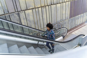 Stilvoller Mann mit Fahrrad auf Rolltreppe - AFVF03888