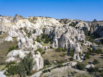 Aerial view of volcanic landscape against clear blue sky during sunny day in Goreme, Cappadocia, Turkey - KNTF03068