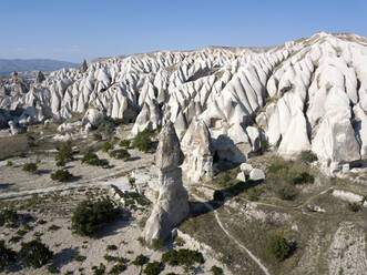 Aerial view of volcanic landscape against blue sky at Cappadocia during sunny day, Turkey - KNTF03072