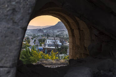 Göreme Stadt gesehen durch Höhle während Sonnenaufgang, Kappadokien - KNTF03103