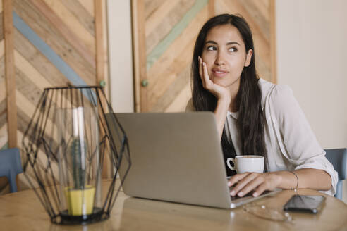 Young businesswoman with laptop at table in a cafe having a break - ALBF00971