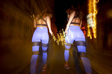 Langzeitbelichtung von zwei Frauen, die nachts in der Stadt laufen - OCMF00585