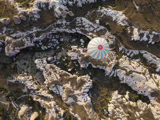 Aerial view of hot air balloon flying over rock formations at Goreme National Park, Cappadocia, Turkey - KNTF03138