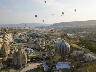 Luftaufnahme von bunten Heißluftballons, die über das Land im Goreme-Nationalpark, Kappadokien, Türkei, fliegen - KNTF03147