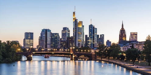 Illuminated buildings by river against clear sky during sunset in Frankfurt, Germany - WDF05427