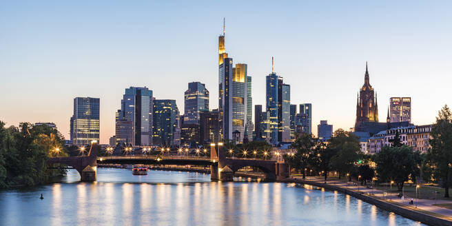 Beleuchtete Gebäude am Fluss gegen den klaren Himmel bei Sonnenuntergang in Frankfurt, Deutschland - WDF05427