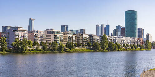Residential buildings and Westhafen Tower by river against clear sky in Frankfurt, Germany - WDF05437