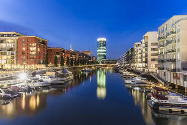 Yachts moored at harbor with illuminated Westhafen Tower in background at Frankfurt, Germany - WDF05460