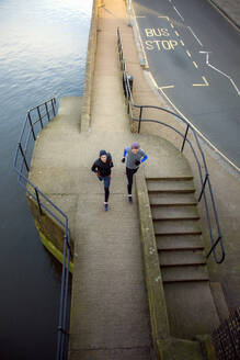 Zwei Jugendliche joggen entlang eines Flusses - AJOF00003