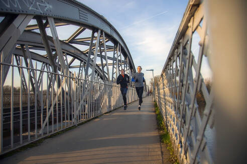 Zwei Teenager rennen über eine Eisenbahnbrücke - AJOF00004