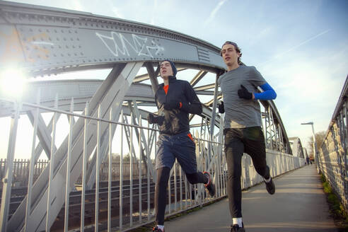 Two teenagers running over railway bridge - AJOF00005