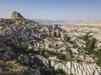 Aerial view of Uchisar castle and buildings against blue sky in Cappadocia, Turkey - KNTF03150