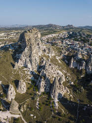 Luftaufnahme der Burg Uchisar mit Gebäuden gegen den klaren blauen Himmel in Kappadokien, Türkei - KNTF03158