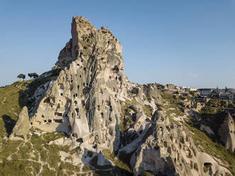 Aerial view of Uchisar castle against blue sky in Cappadocia during sunny day, Turkey - KNTF03161