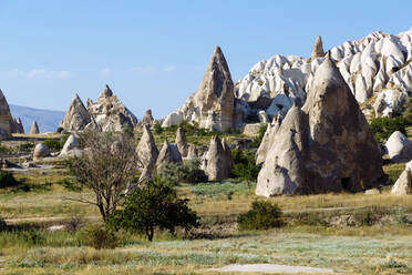 Scenic view of rock formations at Dove Valley against blue sky during sunny day, Cappadocia, Turkey - KNTF03213