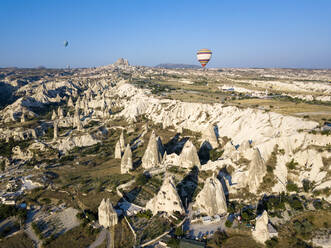 Luftaufnahme von Heißluftballons, die über die Landschaft bei Uchisar, Kappadokien, Türkei, fliegen - KNTF03240