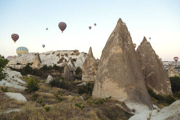 Heißluftballons fliegen über felsige Landschaft gegen klaren Himmel, Kappadokien, Türkei - KNTF03246